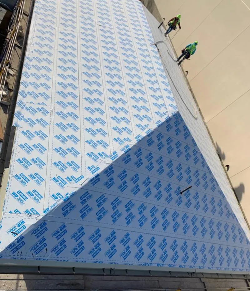 Professional roofers installing underlayment on a metal roof in Delaware